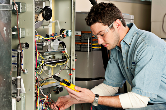 Technician inspecting a furnace with a multimeter, highlighting signs of furnace malfunctions during a repair process.