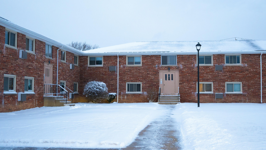 Brick apartment building in Indianapolis covered in snow, showing winter conditions that can cause freeze thaw damage, cracking, and moisture issues in brick masonry