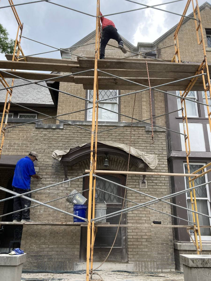 Stone facade work with scaffolding on a two-story home